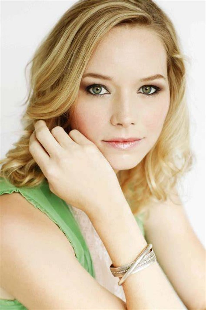 Adrienne Pickering posing for picture by wearing beautiful dress.
